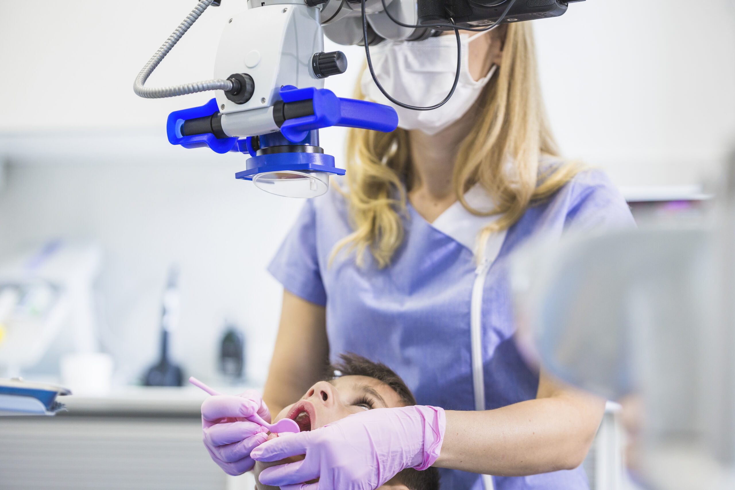 dentysta-bada-pacjenta-zeby-przez-mikroskop-w-klinice-1-scaled.jpg
